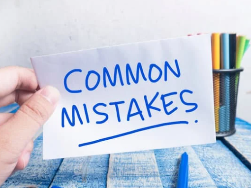 A hand holding a paper which wrote with wording Common Mistakes