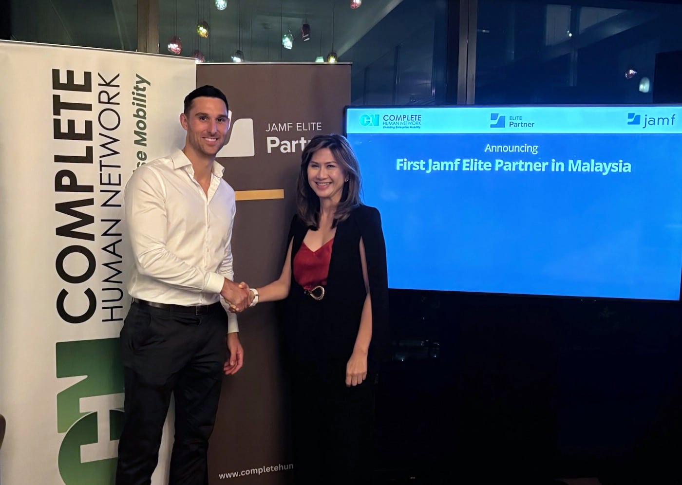 Ceo of complete human network shaking hand with ceo of Jamf