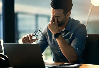 A guy frustrating sitting in front of his laptop
